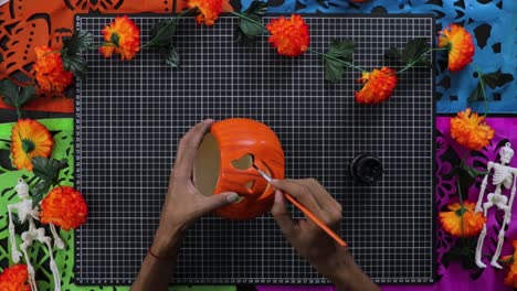 Painting orange pumpkin for Halloween decorations, jack o lantern