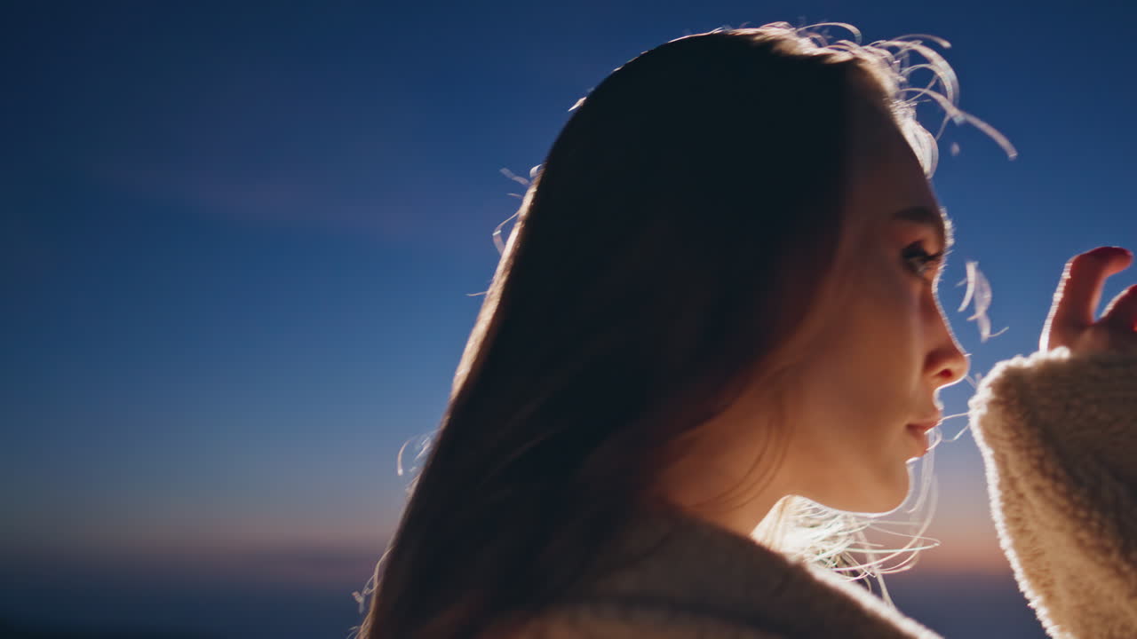 夜空を背景にパーティーを楽しむ魅惑的な女性のクローズアップ。夕暮れ時にポーズをとるモデル。