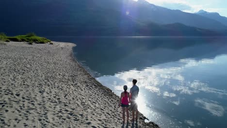 couple standing together on lakeshore 4k