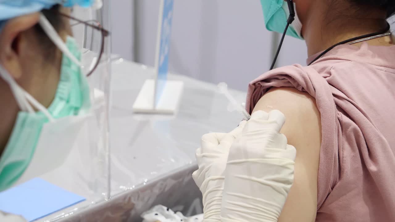 el personal médico asiático administra la vacuna, cierra