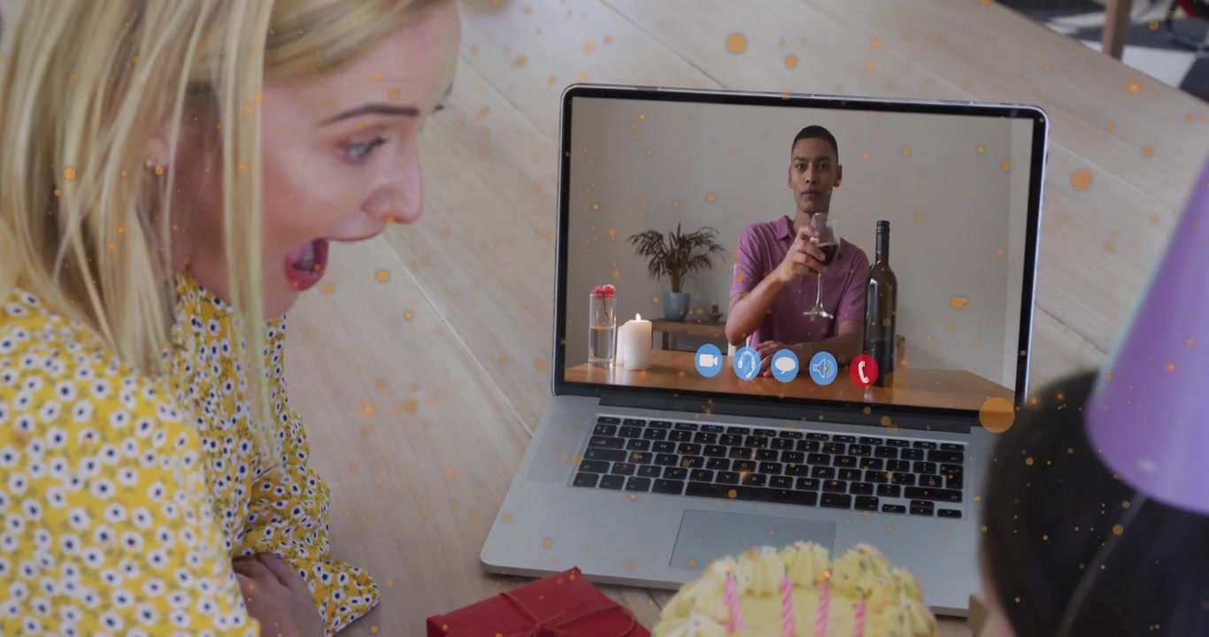 Mor og datter starter videoopkald på bærbar computer og ser vært skåle med drikkevare til fødselsdagsfest med konfetti.
