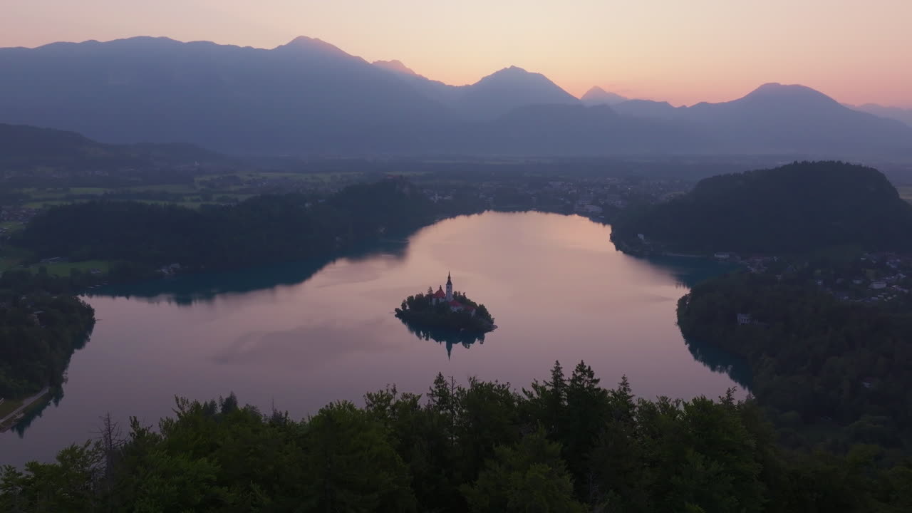 Sorvolo di un drone su una foresta verso l'isola del Lago di Bled