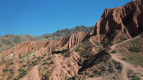 Cinematic-drone-shot-flying-through-mountain-valley-at-Fairy-Tale-Canyon-near-Issyk-Kul-Lake-in-Karakol,-Kyrgyzstan