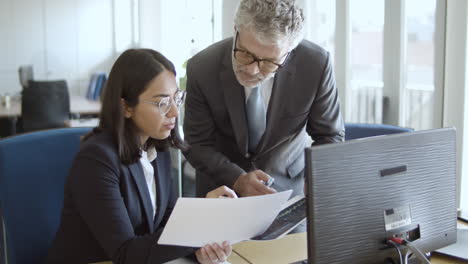 profesional de negocios femenina enfocada comparando datos con un compañero de equipo
