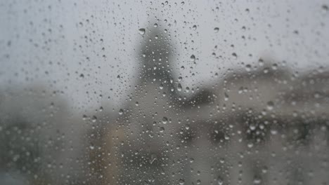 Close-up-view-of-a-rainy-glass-as-rain-drops-are-seen-on-a-window-during-a-gloomy-and-overcast-weather
