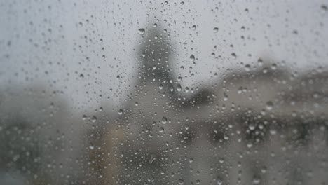 Vista-Cercana-De-Un-Vaso-Lluvioso-Mientras-Se-Ven-Gotas-De-Lluvia-En-Una-Ventana-Durante-Un-Clima-Sombrío-Y-Nublado