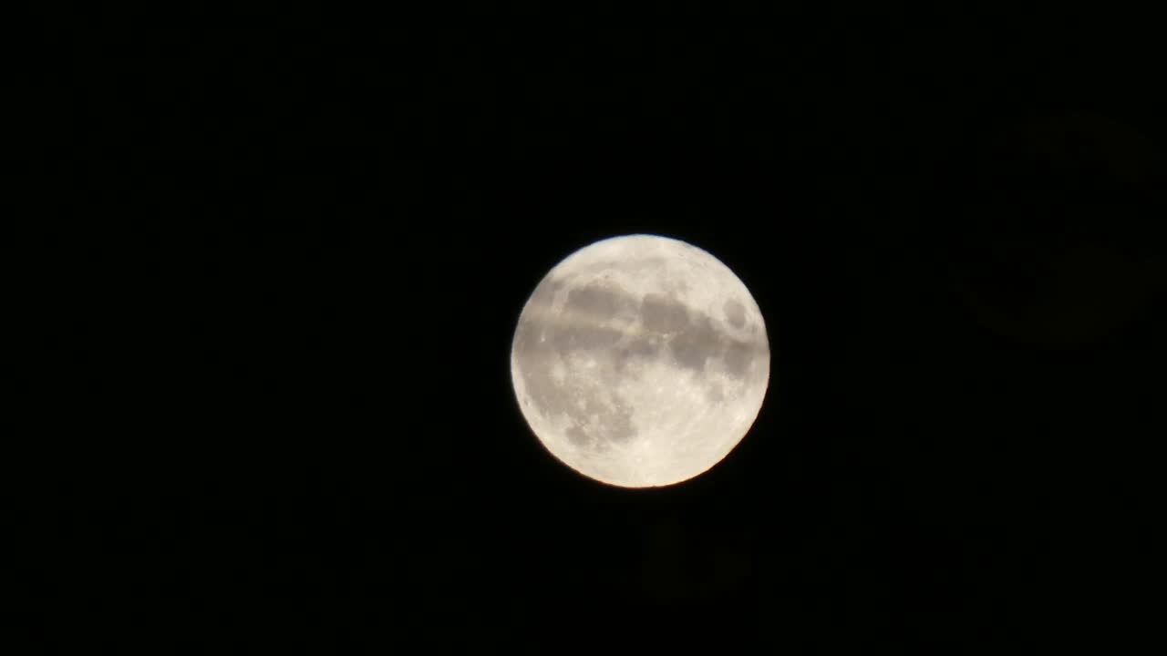 Close-up da superfície da cratera da lua cheia da colheita passando pelo céu escuro com nuvem em primeiro plano