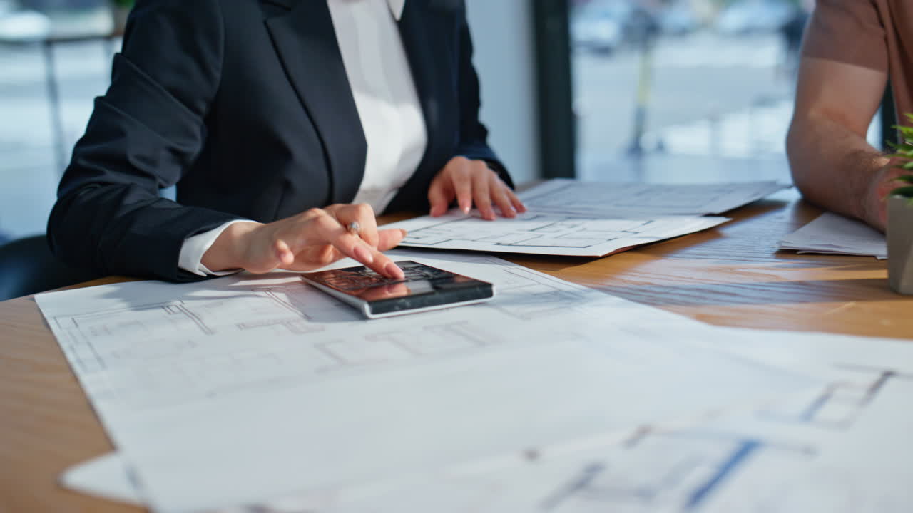 Businesswoman hands pressing calculator at work analyzing documents closeup