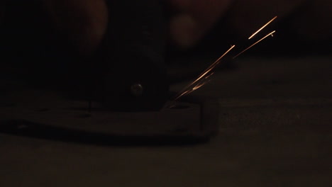 a small rotary disc tool cuts through a metal frame with sparks flying