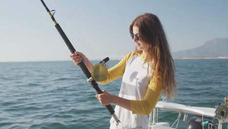 side view of a teenage caucasian girl fishing on boat