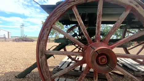 old red wagon wheel in a yard during a sunny day