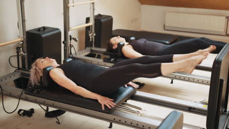 pilates workout with women on reformer machines