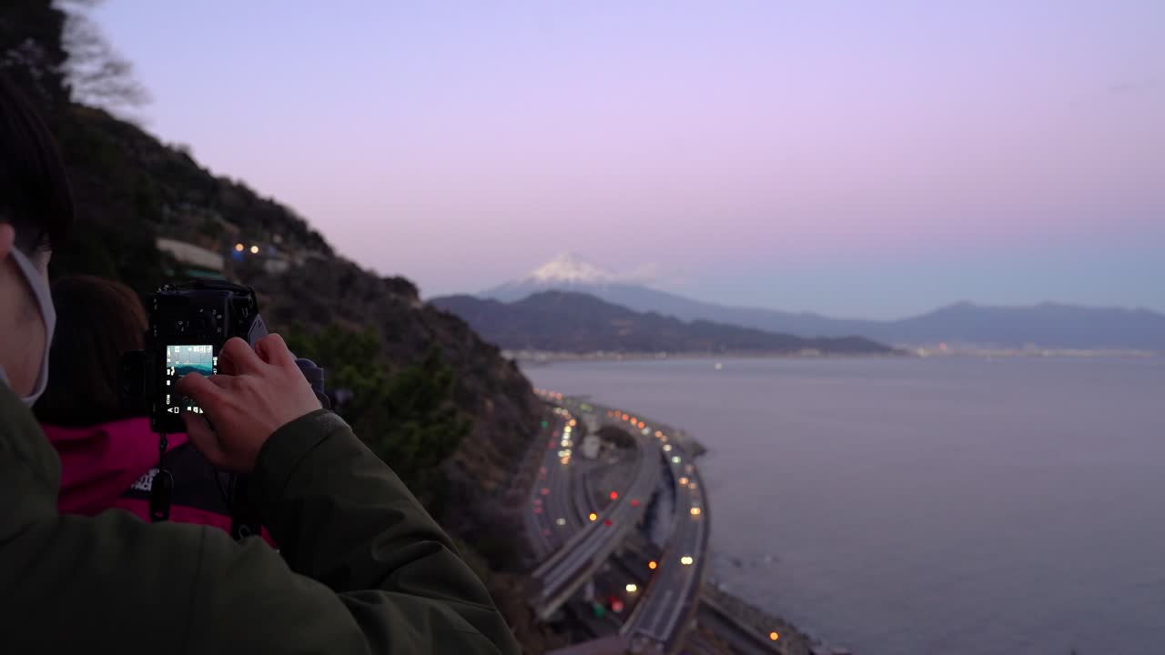 fotógrafo con mascarilla durante la pandemia de covid tomando fotos del paisaje con el monte fuji