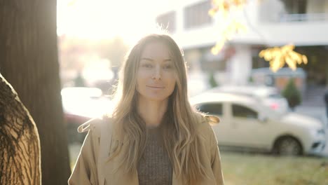 woman in nature near coniferous trees and bright sunlight on the background