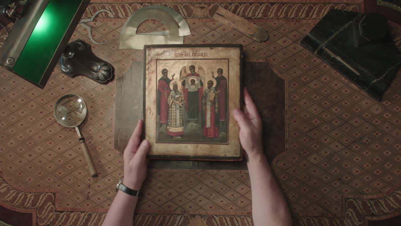 An older man evaluates an old icon painting