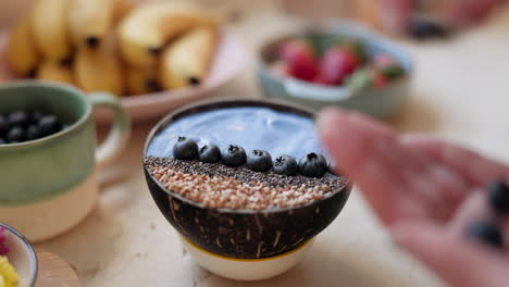 Woman,-hand-and-blueberry-bowl-for-breakfast