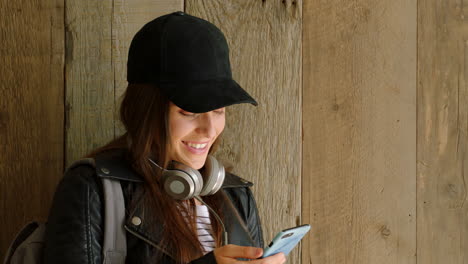 una joven feliz leyendo textos en su teléfono celular