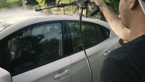 Hombre-Limpiando-Un-Auto-Blanco-Con-Una-Lavadora-A-Presión