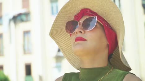 stunning video of a young caucasian female in a green dress with a knitted hat, observing incredible landmark building - sagrada familia, barcelona