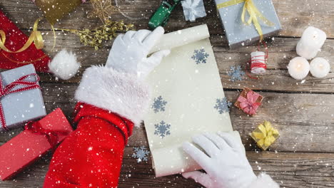 video composition with snow over desk  with santa  revealing paper roll