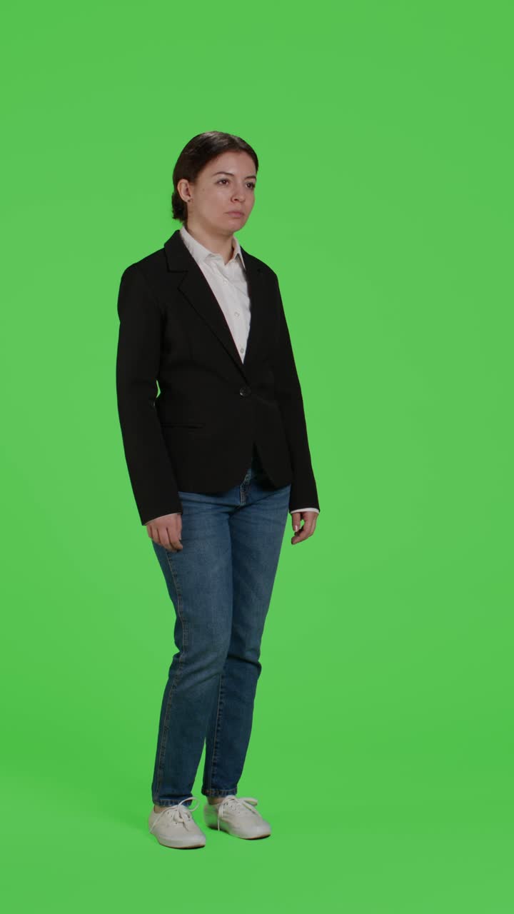 Dikey video: Takım elbise giyen genç bir iş kadınının yandan görünümü, kendinden emin şekilde hareket ediyor