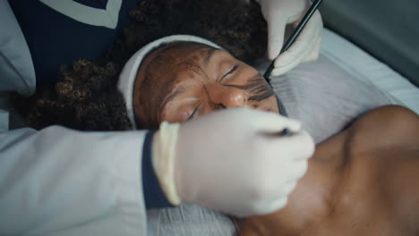 hands applying face mask in spa salon closeup. relaxed patient visit cosmetician