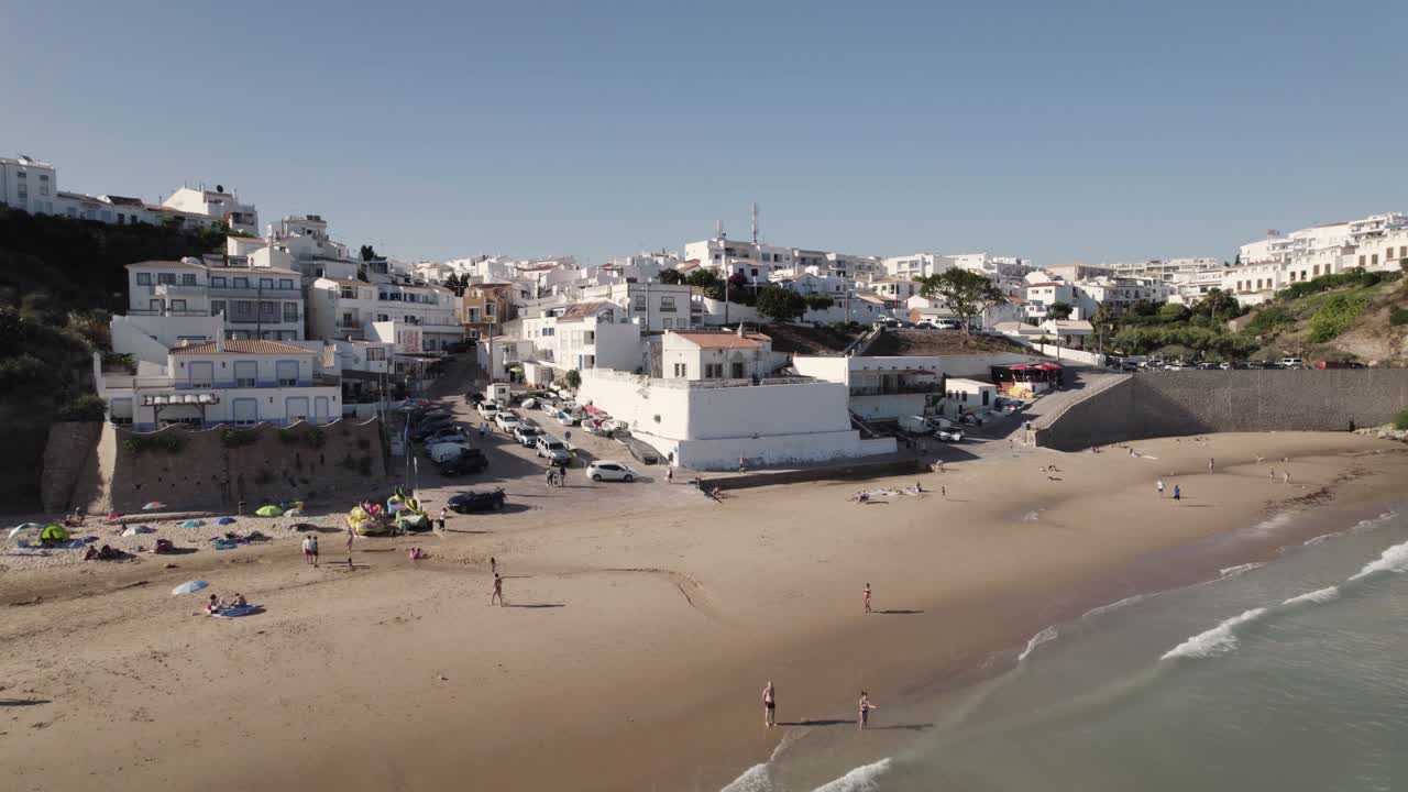 Vista aerea panoramica cinematografica della spiaggia di Burgau e degli edifici imbiancati a calce, Algarve, Portogallo