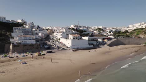 cinematic aerial panning view of burgau beach and whitewashed buildings, algarve portugal