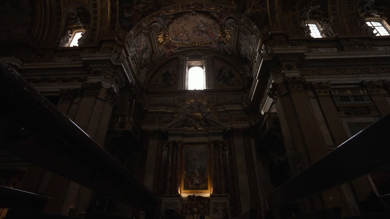 disparo inclinándose hacia arriba entre filas de bancos dentro de una iglesia en roma, italia en 4k