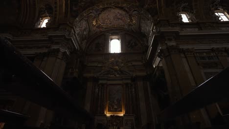 shot-tilting-upwards-between-rows-of-benches-inside-a-church-in-Rome,-Italy-in-4k