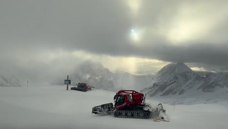 스노우플로우 (snowplows) 는 구름이 가득한 하늘 아래 스피츠 (zugspitze) 에서 눈을 아내며 빛을 한눈에 볼 수 있다.