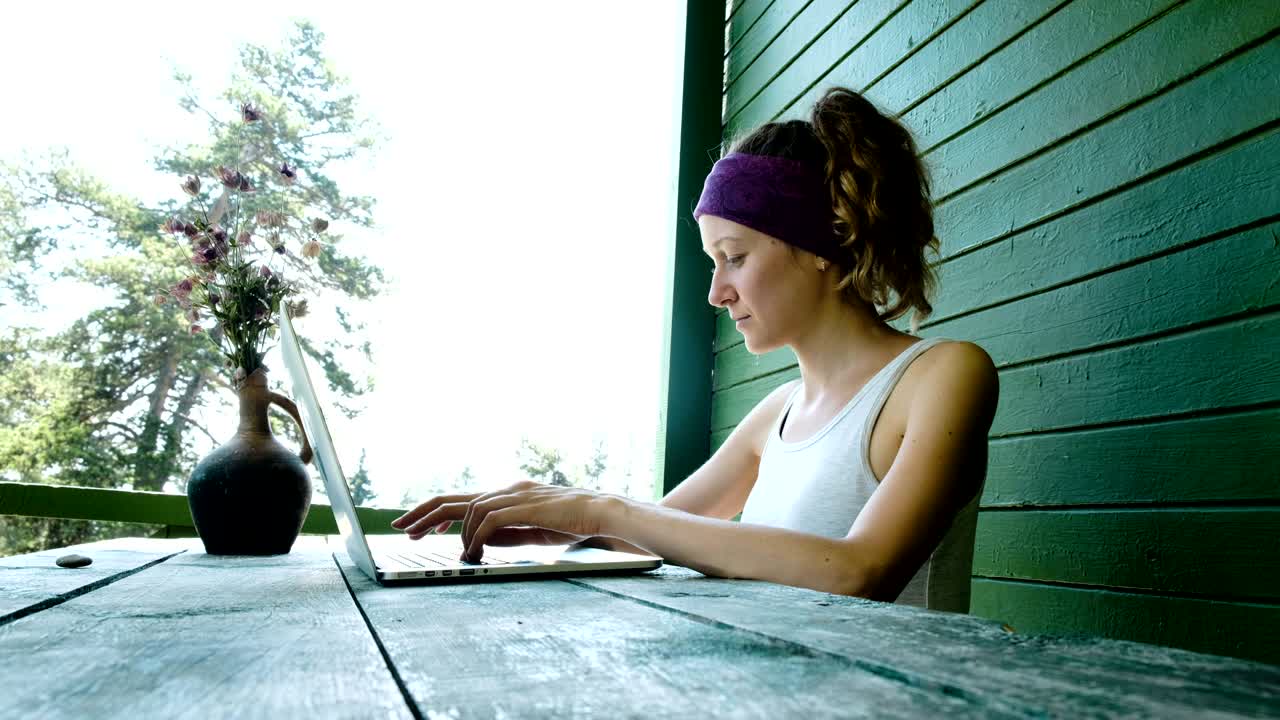 joven mujer de negocios turista independiente escribiendo en una computadora portátil en el verano al aire libre en el centro de recreación