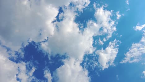 Sky-time-lapse-clouds-and-blue-sunny-sky,-Loop-of-white-clouds-over-blue-sky-with-sun-Rays,-Aerial-view,-drone-shooting-clouds-motion-time,-nature-blue-sky-a-white-clear-weather