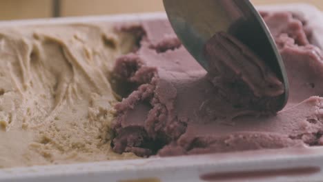 una cuchara toma una cuchara de helado artesanal italiano en sabores de avellana, pistacho y fresa de una bañera