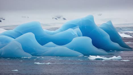 stunning icebergs reflecting shades of blue in a serene arctic scene under a gray sky, highlighting the beauty of nature's frozen masterpieces