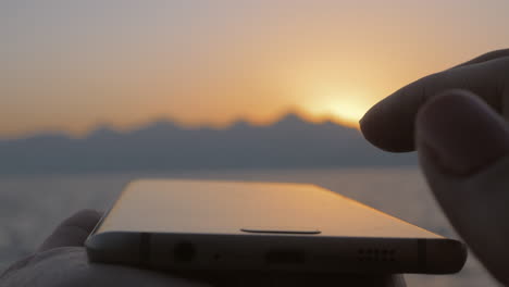 smartphone in front of the evening sea landscape