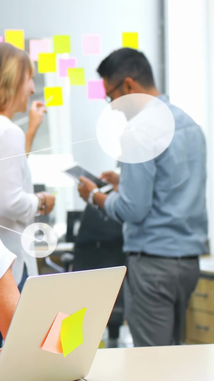 Video verticale: Uomo che usa un tablet, donna che appende appunti al muro, creando una sovrapposizione tecnologica per mappare le idee.