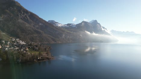 -Aerial-parallax-view-of-Alps-with-clouds-in-Walensee,-Switzerland