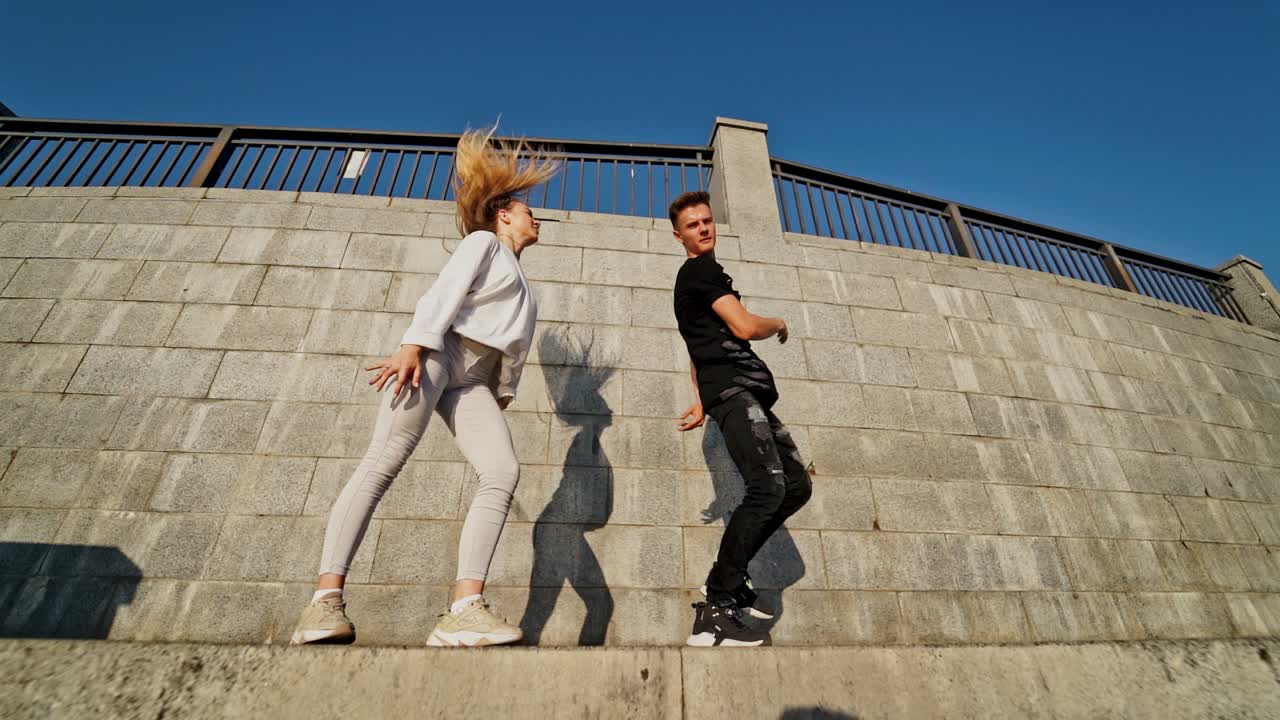 Dancing couple in city. Outdoor view of young beautiful fashionable couple dancing in street