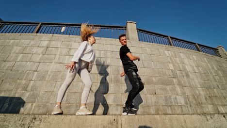 dancing couple in city. outdoor view of young beautiful fashionable couple dancing in street