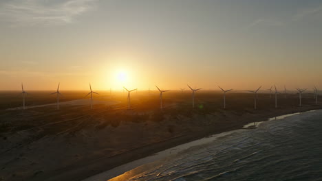 High-up-drone-shot-of-wind-turbines-in-the-dunes-during-sunset