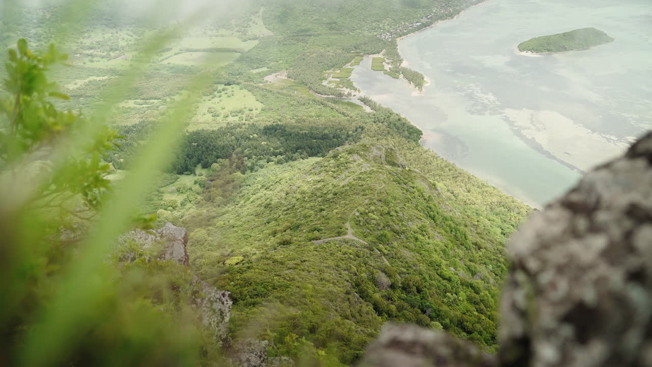 A top view from le morne on the Mauritian coastline. Grass is softly visible in the foreground.