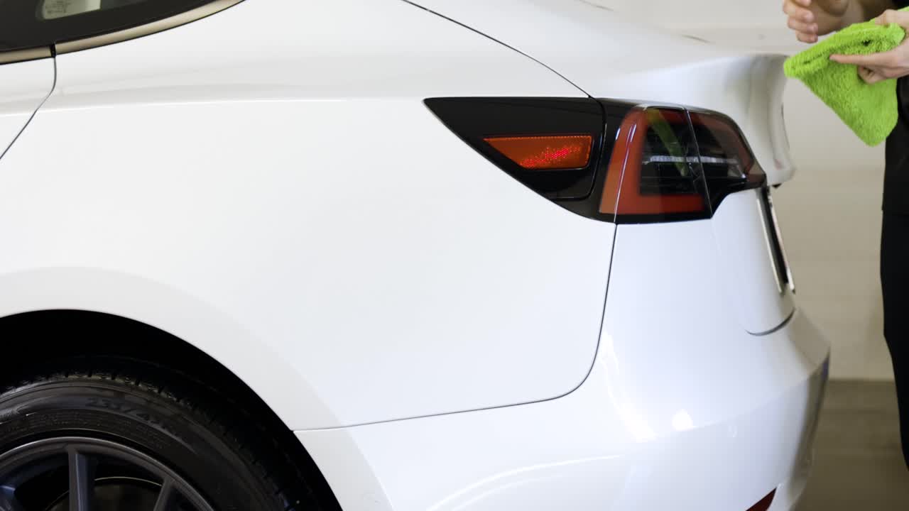 테슬라 모델 3의 뒷등이 차 세탁 후에 지워지고 있습니다.