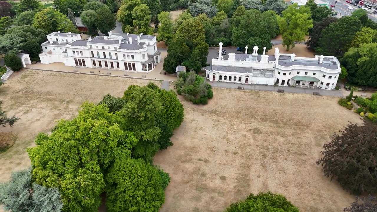 Dimore storiche e le loro facciate colonnate si affacciano su un parco arido in un grande parco pubblico.