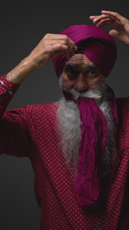 a sikh man adjusting his turban