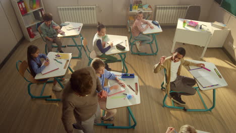 diverse group of children having lesson in classroom with teacher