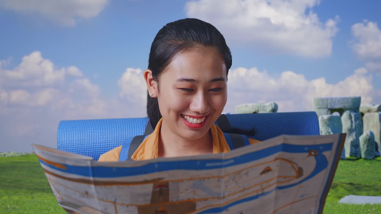 Close Up Of Asian Female Hiker With Mountaineering Backpack Looking At The Map Then Looking Around While Traveling In Stonehenge