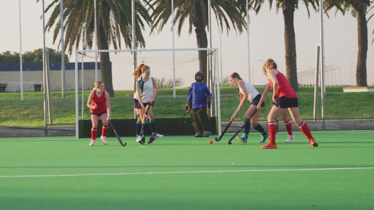 여자 하키 선수 들 이 경기장 에서 뛰고 있다