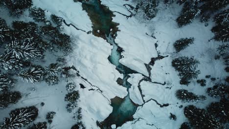winter river aerial cinemagraph seamless video loop of a scenic and idyllic canyoning waterfall with fresh natural blue water in the bavarian austrian alps, flowing along snow canyon forest trees. 4k uhd. rissach tyrol austria engtal ahornboden