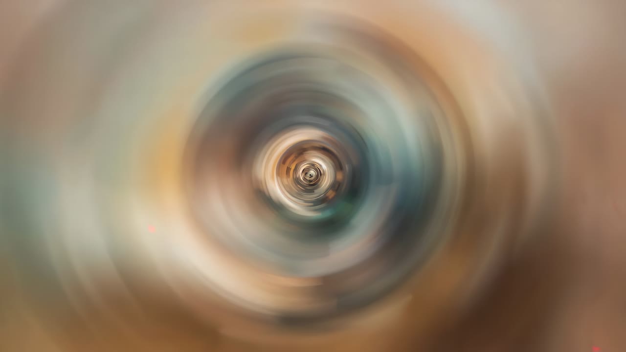 Rotating central swirl reacting to frames, pulsing inward in abstract field beige tan teal rings